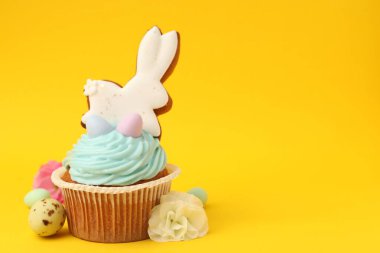 Turuncu arka planda Paskalya dekoru olan lezzetli bir kek, yakın plan. Metin için boşluk