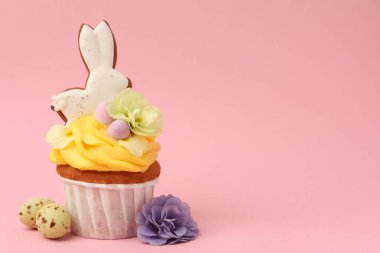 Pembe arka planda Paskalya dekoru olan lezzetli bir kek, yakın plan. Metin için boşluk