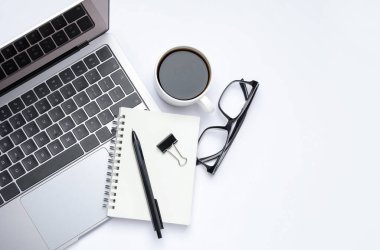 Laptop, kırtasiye malzemeleri, beyaz arka planda kahve ve bardaklar, düz konum. Metin için boşluk