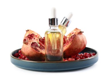 Beyaz üzerine izole edilmiş gerekli yağ ve taze nar şişeleri.