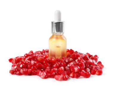 Beyaz üzerine izole edilmiş bir şişe yağ ve nar tohumu.
