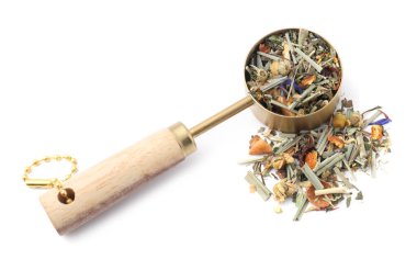 Kurutulmuş bitki çayı ve ölçü kaşığı beyaza izole edilmiş.