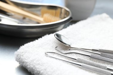 Masada farklı diş aletleri ve havlu, yakın plan.