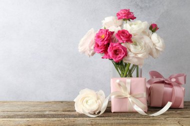Tahta masada güzel çiçekler ve hediyeler. Metin için boşluk