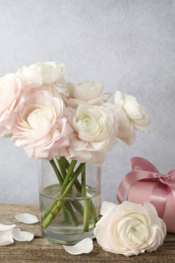 Güzel çiçekler ve hediye ahşap masada.