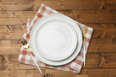 Ahşap masadaki çatal bıçaklı şık bulaşık takımı.