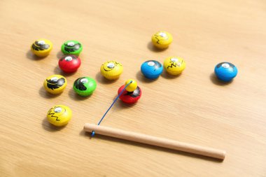 Çocuk oyuncağı. Tahta masa üzerinde olta ve manyetik figürleri olan çocuklar için seti ayırmak, yakın plan