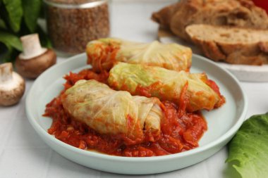 Beyaz fayanslı masada servis edilen lezzetli lahana dürümleri, yakın plan.