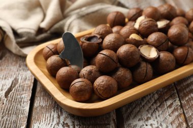 Macadamia fındıkları ve metal anahtar ahşap masada, yakın plan.