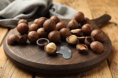 Macadamia fındıkları ve metal anahtar ahşap masada, yakın plan.