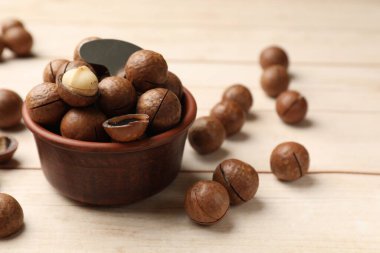 Makadamia fındığı ve metal anahtar açık tahta masada, yakın plan.