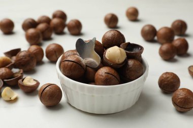 Macadamia fındıkları ve metal anahtar beyaz masada, yakın plan.