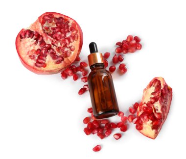 Bir şişe temel yağ, tohum ve taze nar beyaza izole edilmiş.