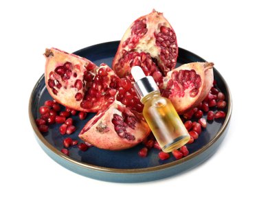 Bir şişe gerekli yağ ve taze nar, beyaz üzerine izole edilmiş.
