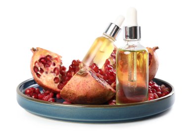 Beyaz üzerine izole edilmiş gerekli yağ ve taze nar şişeleri.