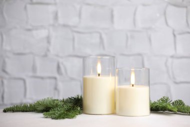 Dekoratif LED mumlar ve kapalı masa üzerindeki köknar dalları. Metin için boşluk