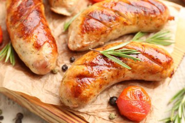 Lezzetli ızgara sosis, domates ve biberiye masada servis edilir.