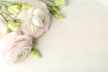 Güzel çiçekler ve hediye beyaz ahşap masada, yakın plan. Metin için boşluk