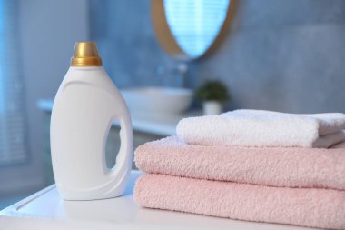 Banyodaki çamaşır makinesine havlu ve deterjan yığını.