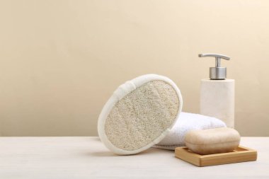 Lif süngeri, havlu ve kozmetik ürünleri beyaz ahşap masada. Metin için boşluk