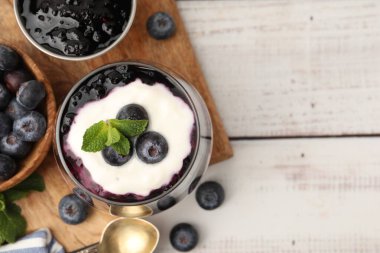Yaban mersinli yoğurt, beyaz ahşap masada reçel ve nane. Metin için boşluk