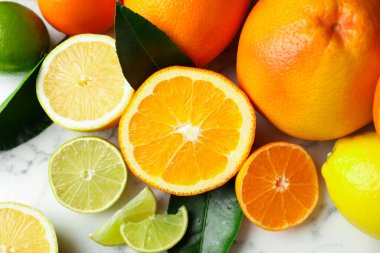 Beyaz mermer masada farklı olgun narenciye meyveleri, düz yatıyordu.