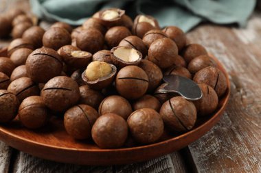 Macadamia fındıkları ve metal anahtar ahşap masada, yakın plan.