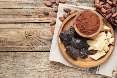 Organik kakao yağı, çikolata parçaları, fasulye ve toz tahta masa, üst manzara. Metin için boşluk