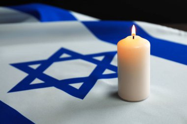 Soykırım Anma Günü. İsrail bayrağında yanan mum, yakın plan