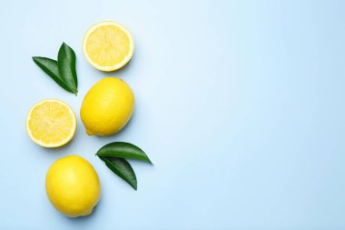 Olgun limonlar ve hafif arka planda yapraklar, düz yatış. Metin için boşluk