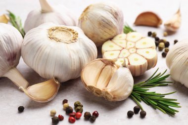 Taze sarımsak, biber ve biberiye açık gri masada, yakın plan.