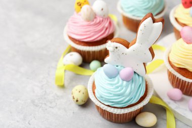 Gri masada Paskalya dekoru olan lezzetli kekler, yakın plan. Metin için boşluk