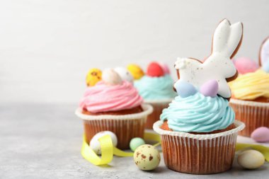 Gri masada Paskalya dekoru olan lezzetli kekler, yakın plan. Metin için boşluk