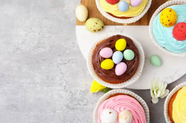 Gri masa üzerinde Paskalya dekoru olan lezzetli kekler. Metin için boşluk