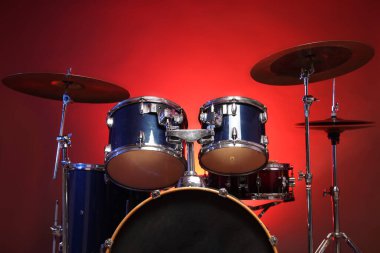 Kırmızı gradyan arka planda davul seti, düşük açı görünümü. Müzik aletleri