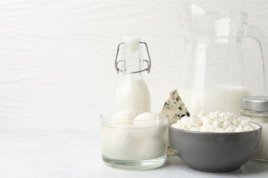 Beyaz fayanslı masa üzerinde farklı süt ürünleri, yakın çekim. Metin için boşluk