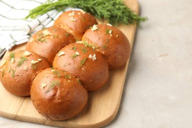 Sarımsaklı taze çörekler ve dereotlar ışık masasında, yakın plan.