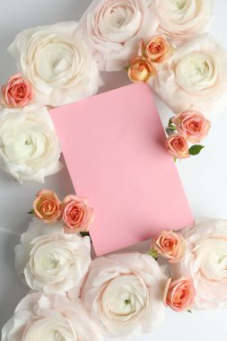 Güzel ranunculuslar, güller ve beyaz arka planda boş bir kart. Tasarım için model