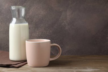 Kupada taze süt ve ahşap masada sürahi. Metin için boşluk