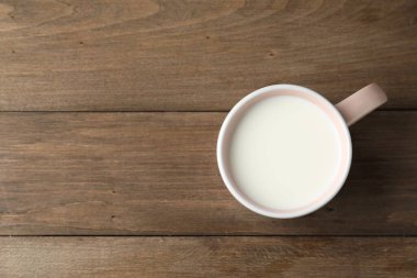 Tahta masadaki kupada taze süt, üst manzara. Metin için boşluk