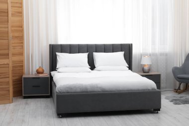 Yatak odasında temiz çarşafları olan rahat bir yatak.