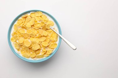 Beyaz masada servis edilen sütle birlikte lezzetli mısır gevrekleri. Metin için boşluk