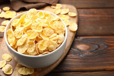 Tahta masadaki kasede lezzetli mısır gevrekleri, yakın plan. Metin için boşluk