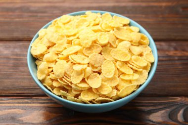 Tahta masadaki kasede lezzetli mısır gevrekleri, yakın plan.