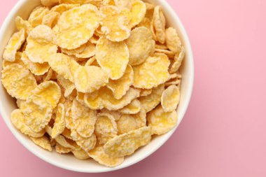 Pembe arka planda kasede lezzetli mısır gevrekleri, üst manzara. Metin için boşluk