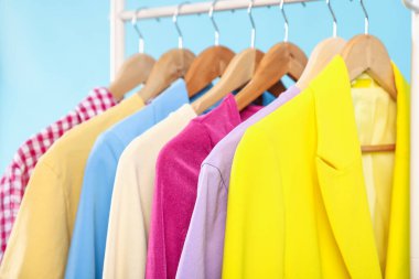 Açık mavi arkaplanda asılı farklı giysiler, yakın plan