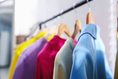 Farklı şık kıyafetler askıda asılı, kapalı, yakın çekim.