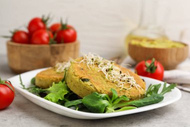 Mikroyeşillikli lezzetli vejetaryen köfteler ve gri masada salata, yakın plan.