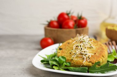 Mikroyeşillikli lezzetli vejetaryen köfteler ve gri masada salata, yakın plan. Metin için boşluk