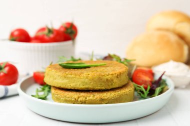 Beyaz fayanslı masada servis edilen salatalı lezzetli vejetaryen köfteleri, yakın plan.